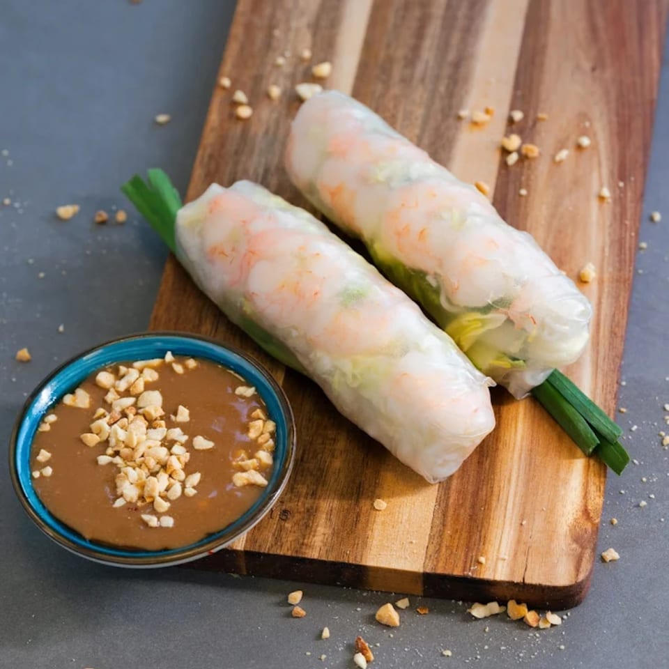 Two fresh Vietnamese spring rolls with shrimp and greens, served with peanut dipping sauce.